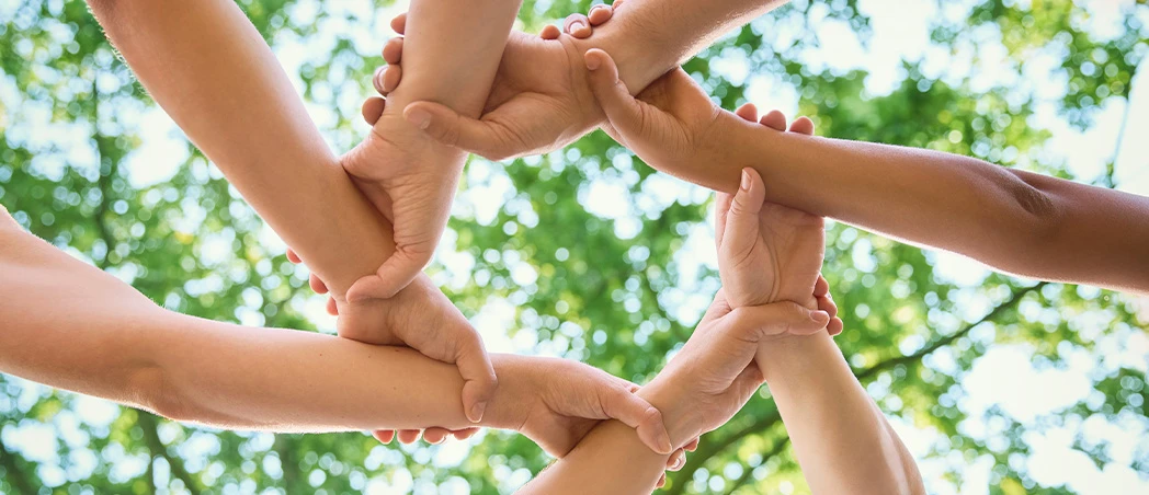 Menschen halten sich gemeinsam an den Armen