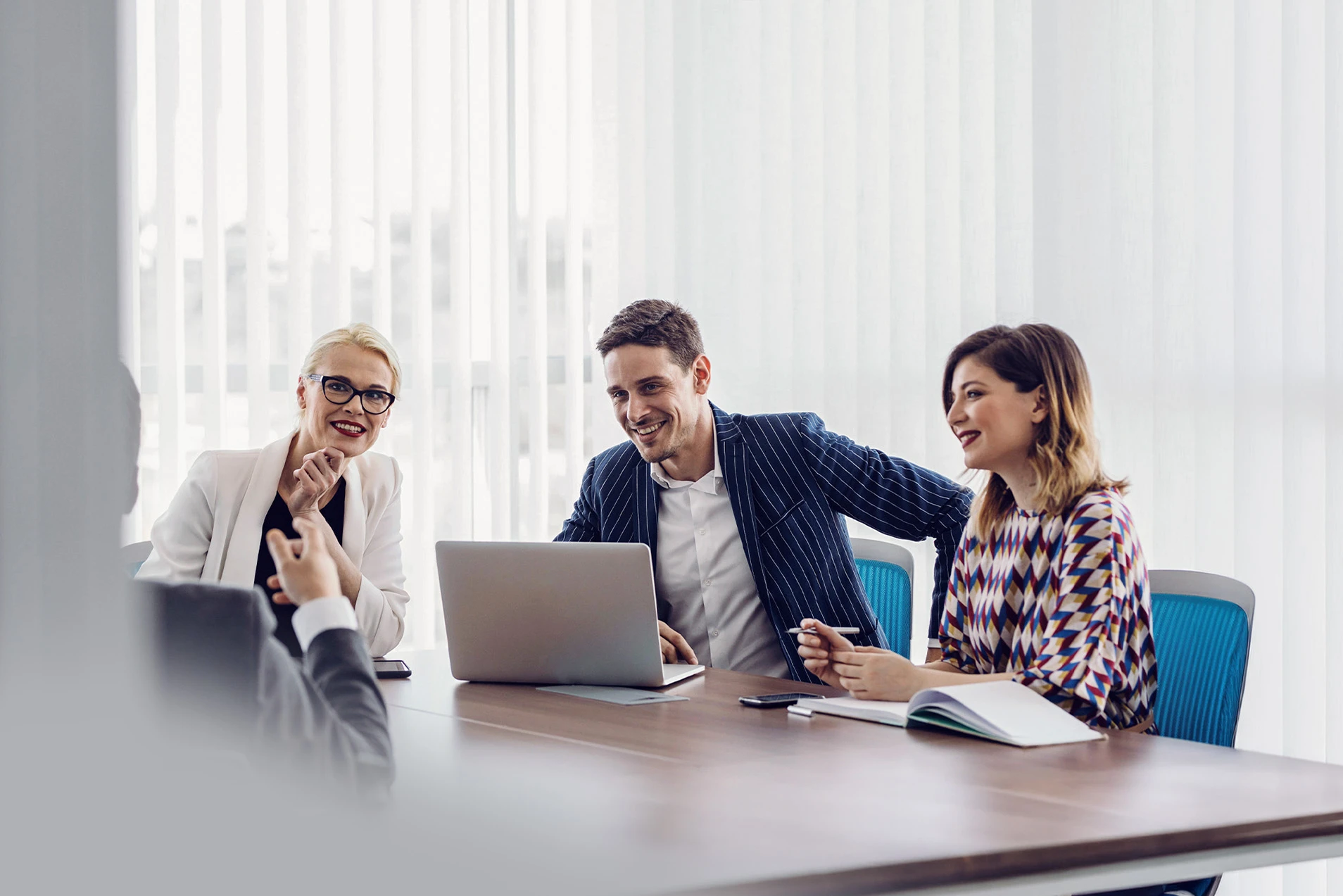 Drei Personen arbeiten gemeinsam am Laptop