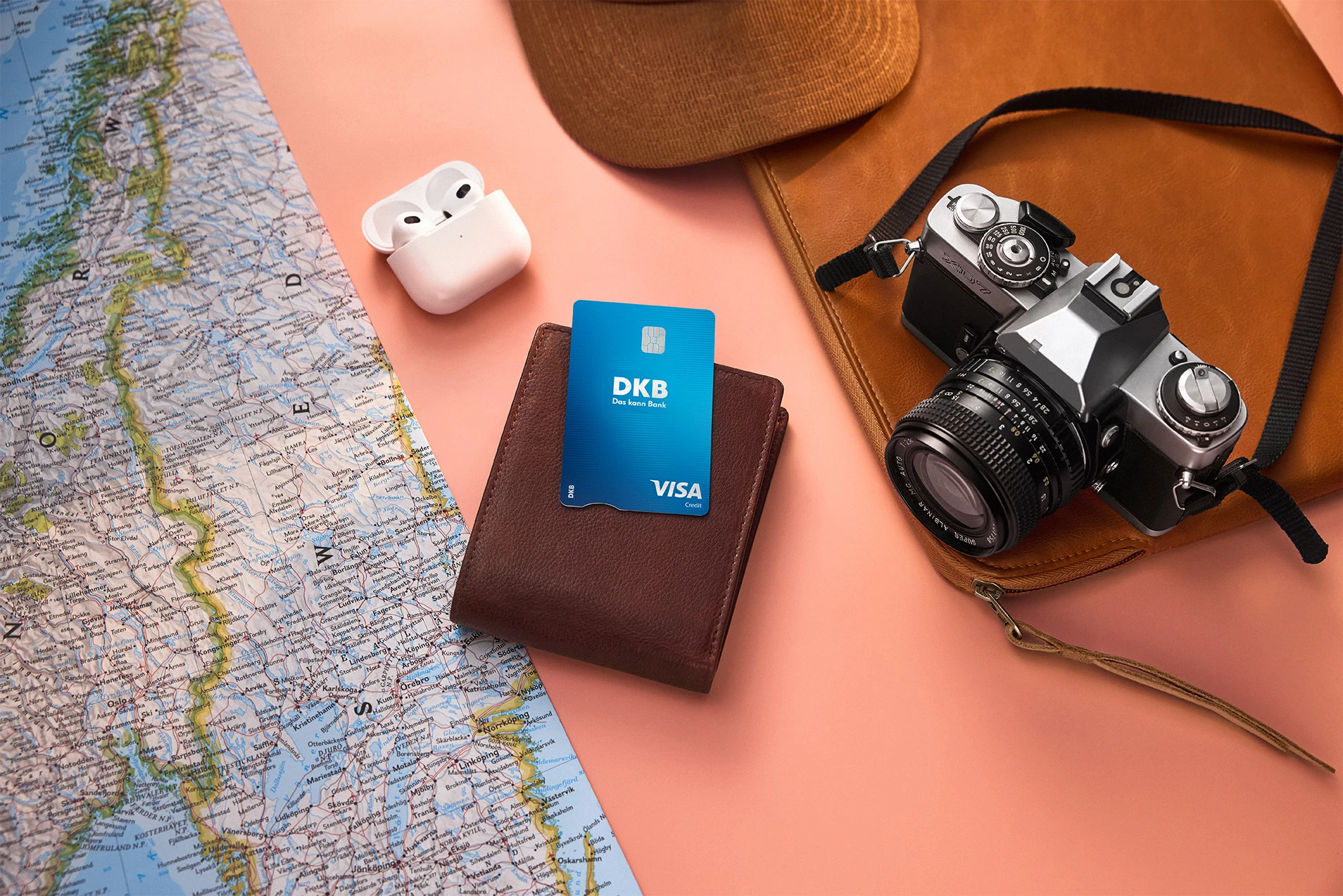 DKB Visa Kreditkarte auf Geldbörse, umgeben von Reiseutensilien