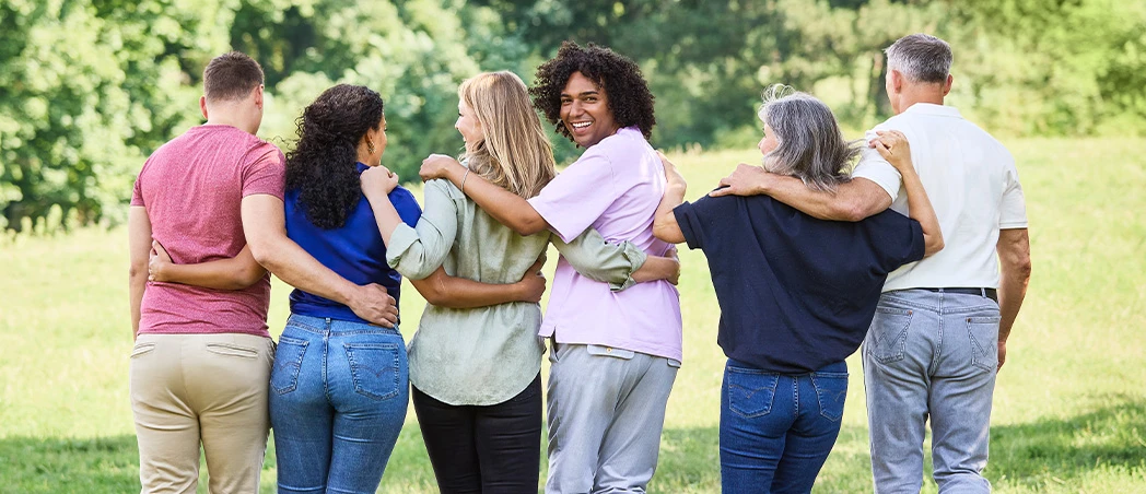 Eine Gruppe von sechs Personen von hinten, umarmen einander