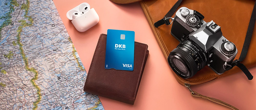 DKB Visa Kreditkarte auf Geldbörse, umgeben von Reiseutensilien