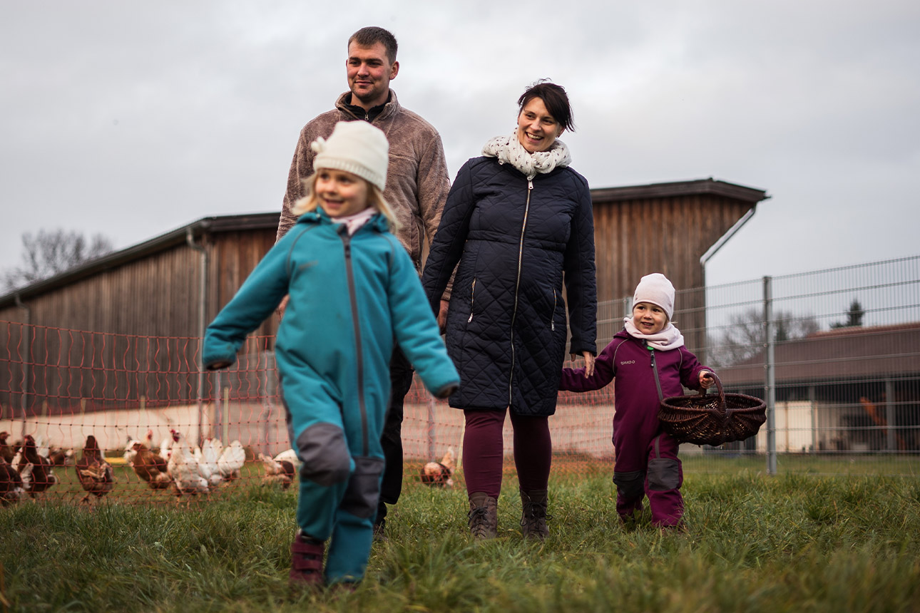 Jungbauer mit seiner Familie bei den Hühnern
