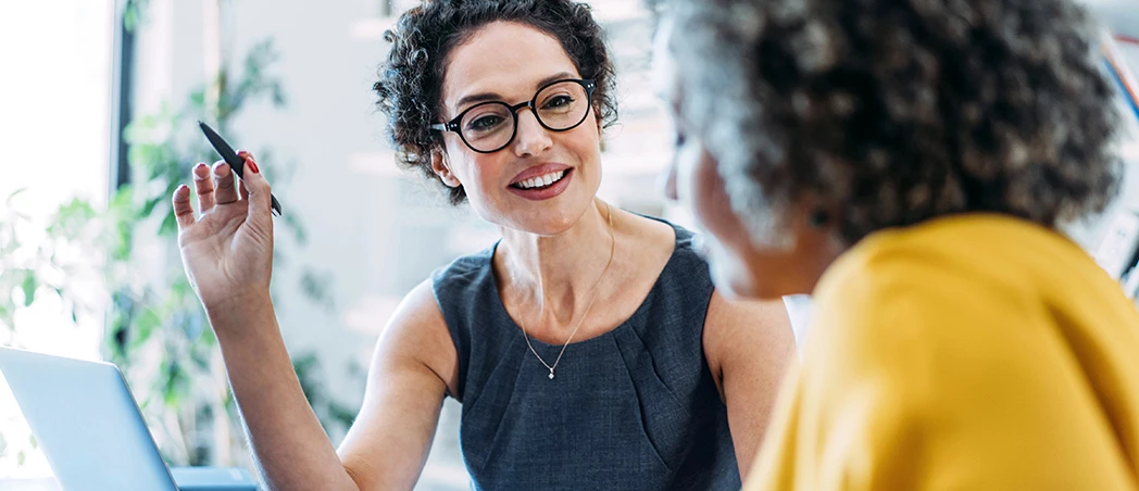 Zwei Frauen diskutieren über Firmengeld-Anlagen