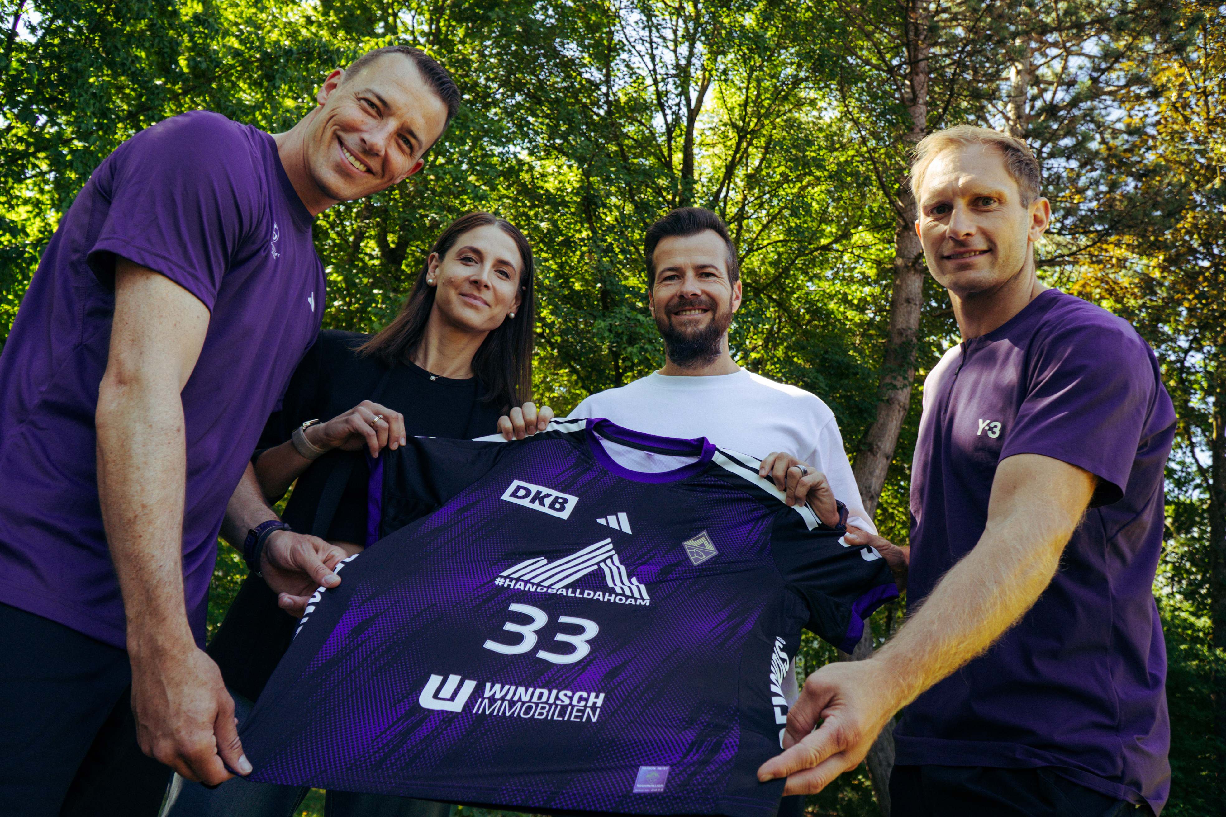 Vier Personen präsentieren ein violettes Trikot