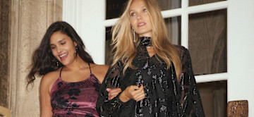 Farbenfrohe Outfits: Leuchtend orange Pullover und gelbe Jacke. Sonnenbrillen und lächelnde Gesichter.