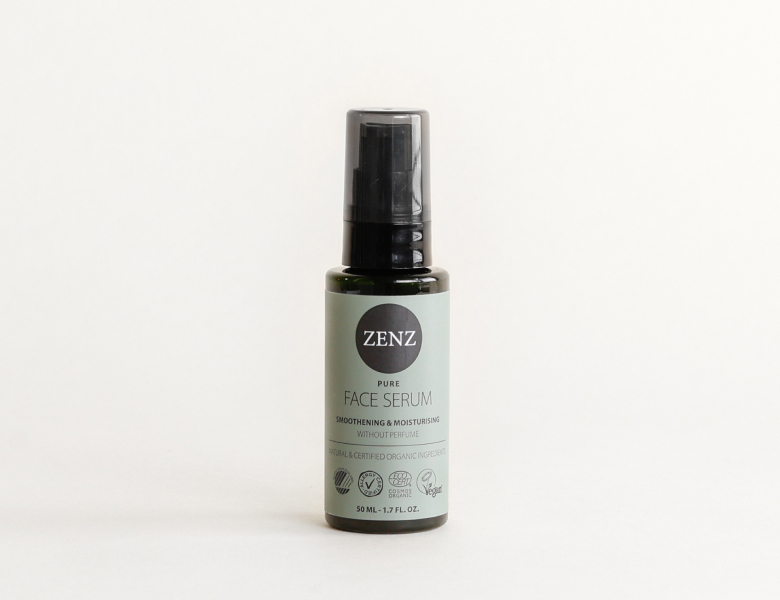 Her ses et ZENZ face serum i en mørk flaske med pumpe på en lys baggrund.