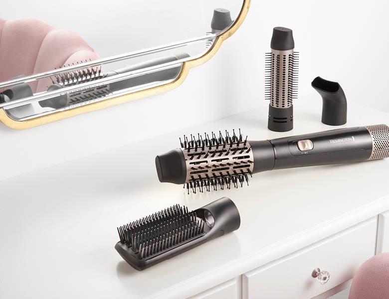 Her ses forskellige hårstylere på et hvidt bord.