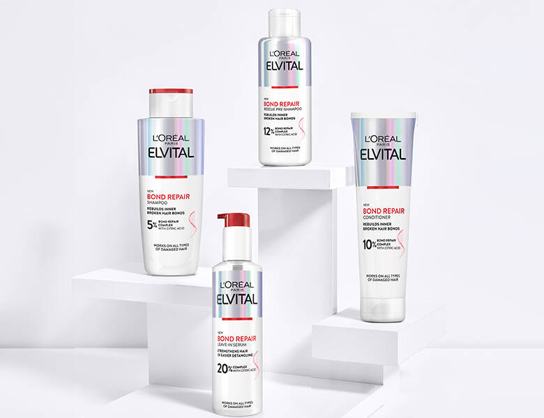 Her ses fire hvide, sølv og røde L'Oréal Paris produkter på en hvid baggrund.