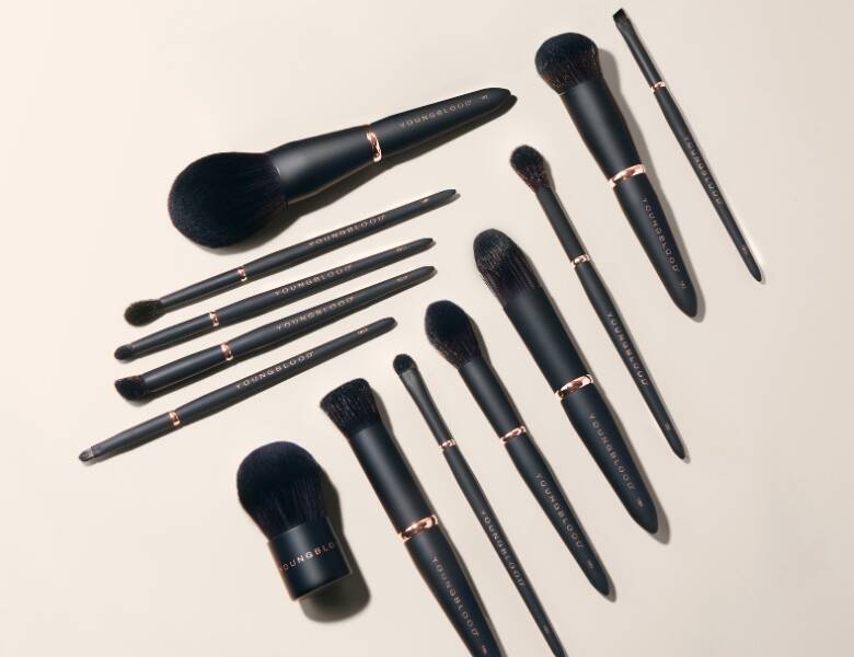Her ses mange forskellige makeupbørster, som alle er sorte, på en lys baggrund.