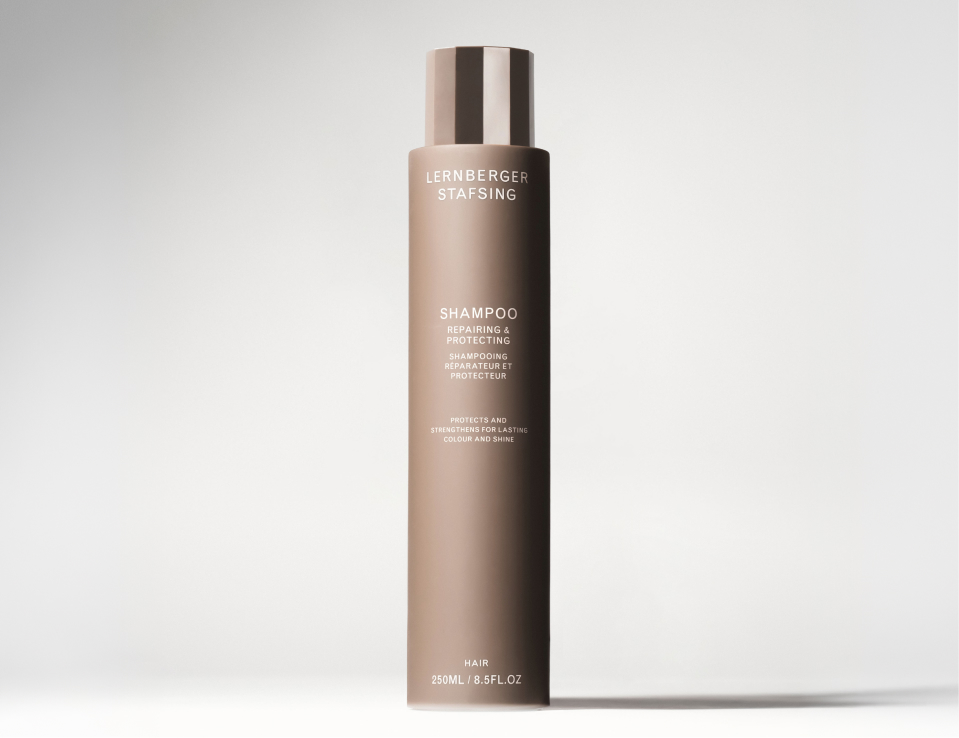 Her ses Lernberger Stafsing Shampoo Repairing & Protecting i en brun flaske mod en lys baggrund.