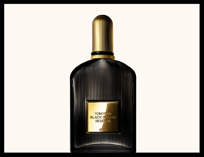 Her ses en sort parfumeflakon med guldlåg på en beige baggrund. Rundt om er en sort ramme.
