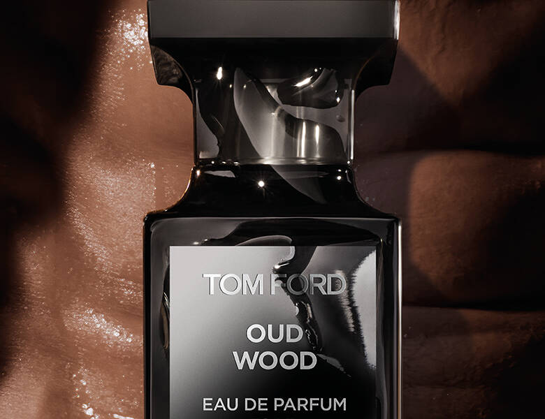 Her ses en mørkebrun baggrund med en sort Tom Ford parfume.