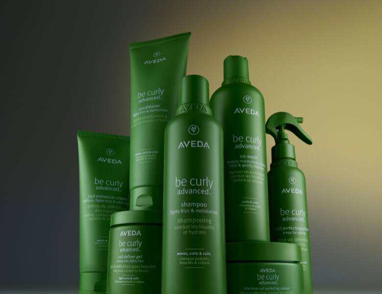 En serie grønne Avedaprodukter på en mørk baggrund