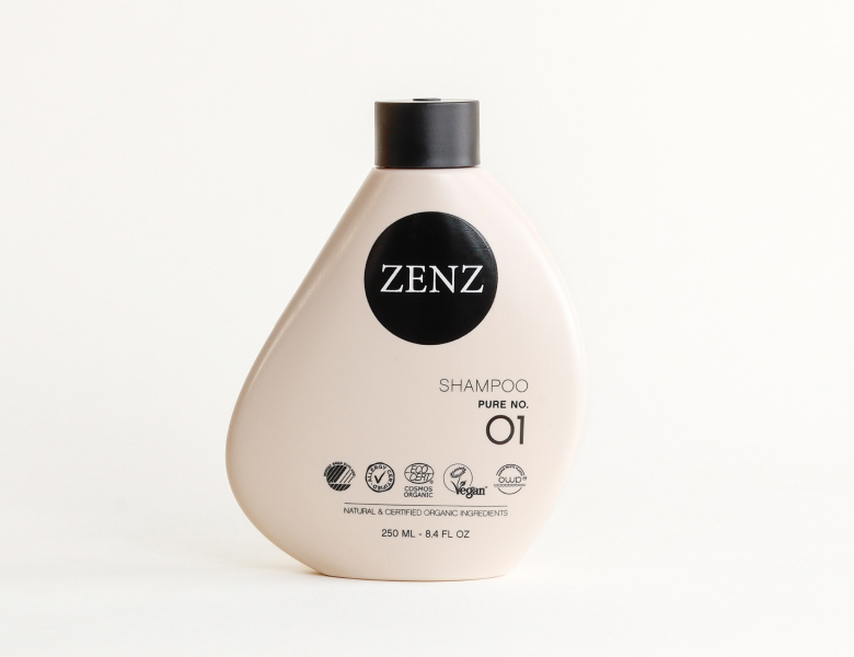 Her ses en ZENZ shampoo i en lys flaske med sort låg på en lys baggrund.