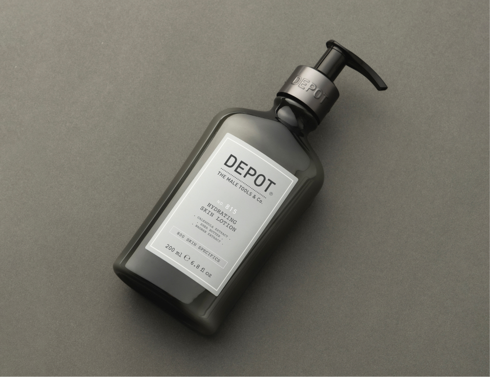 Her ses DEPOT No. 815 Hydrating Skin Lotion i en mørk flaske med pumpe, placeret mod en grå baggrund.