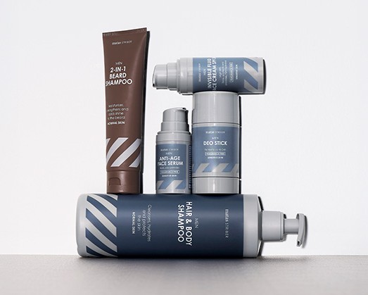 Her ses Matas Striber produkter til mænd – shampoo, deodorant og ansigtsserum i blå og brun emballage på en lys baggrund.