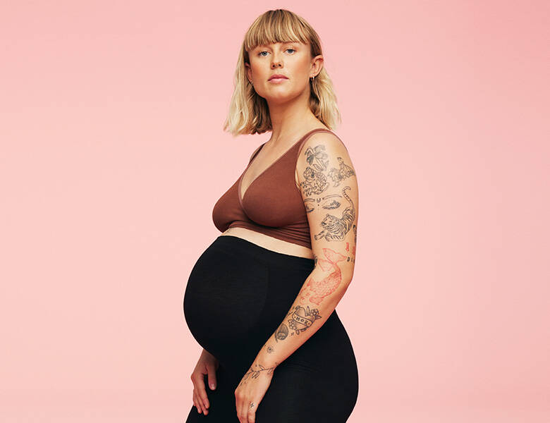 Her ses en lyserød baggrund med en gravid kvinde på.