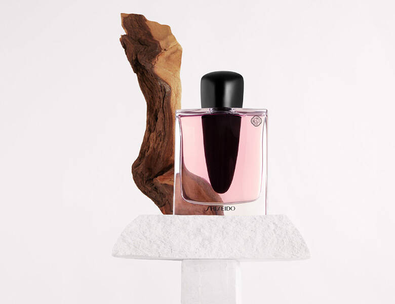 Her ses en lyserød parfume på en hvid baggrund.