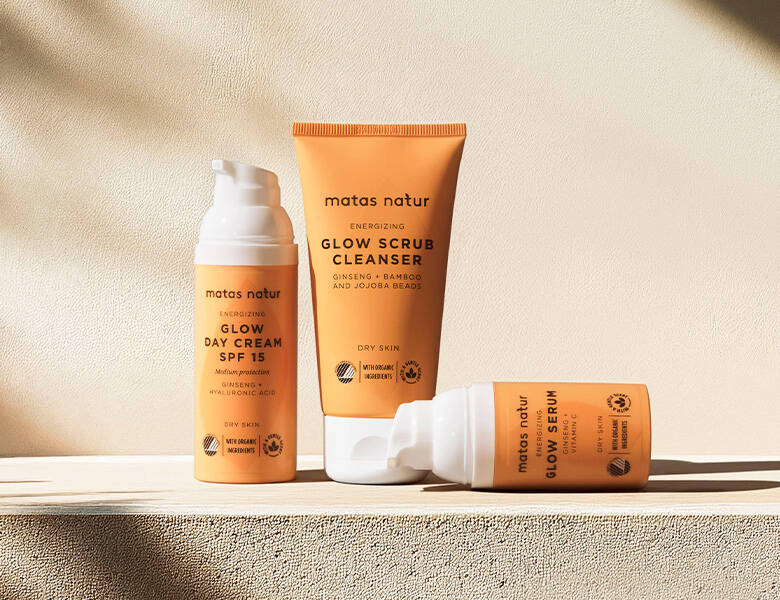 Her ses tre orange produkter på en lys mur.