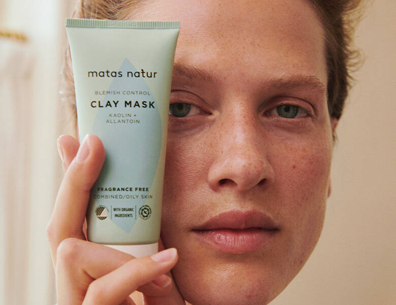 Her ses en, som holder et blå-grønt produkt op mod kinden.