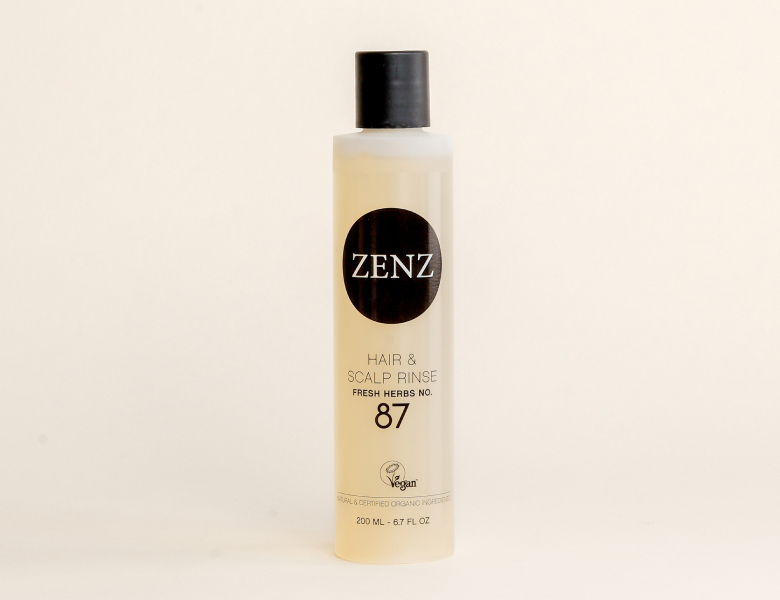 Her ses en ZENZ hair & scalp rinse i en lys flaske med sort låg på en lys baggrund.