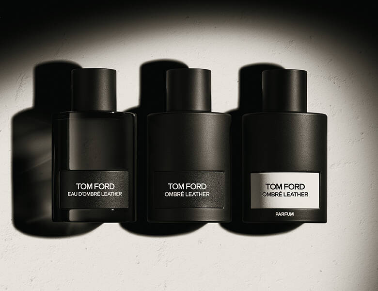 Her ses en grå baggrund med tre sorte Tom Ford parfumer.