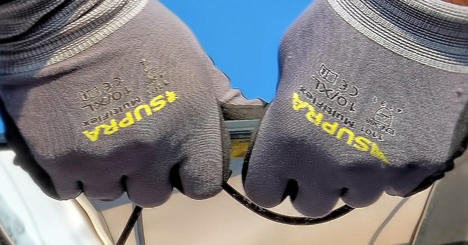 Detailshot van handen die een kabel van Solen aan het verwerken zijn