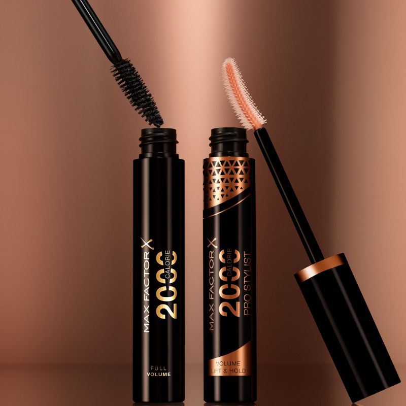 Två mascaror från Max Factor med sina borstar synliga, placerade mot en kopparfärgad bakgrund.