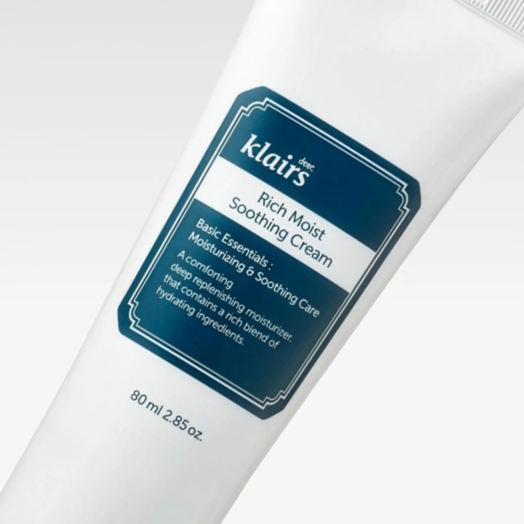 Klairs Rich Moist Soothing Cream -kosteusvoide valkoisessa tuubissa vaaleaa taustaa vasten. Pakkauksessa näkyvät tekstit "Rich Moist Soothing Cream", "Basic Essentials: Moisturizing & Soothing Care", "A comforting deep replenishing moisturizer that contains a rich blend of hydrating ingredients." sekä "80 ml / 2.85 oz."