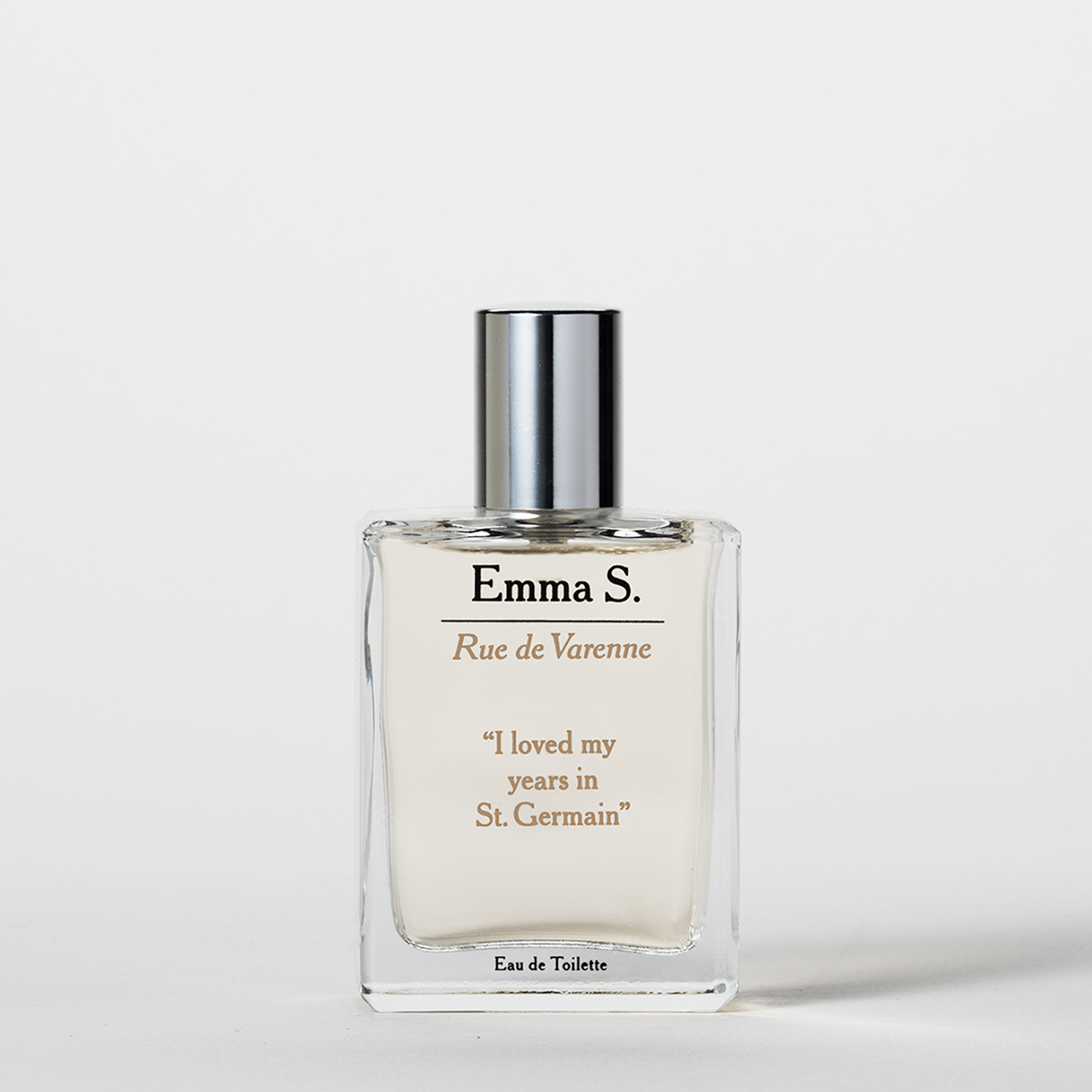 Transparent parfymeflaske fra Emma S med sølvfarget kork og teksten “Rue de Varenne”, “I loved my years in St. Germain” og “Eau de Toilette” på en lys bakgrunn.