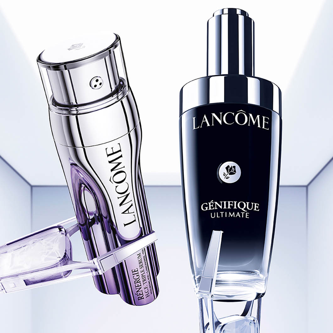 Kaksi Lancômen seerumipulloa on vaaleaa taustaa vasten, “Rénergie H.C.F. Triple Serum” ja “Génifique Ultimate”. Pulloissa on hopeiset yksityiskohdat ja pipetit näkyvät tuotteiden edessä.