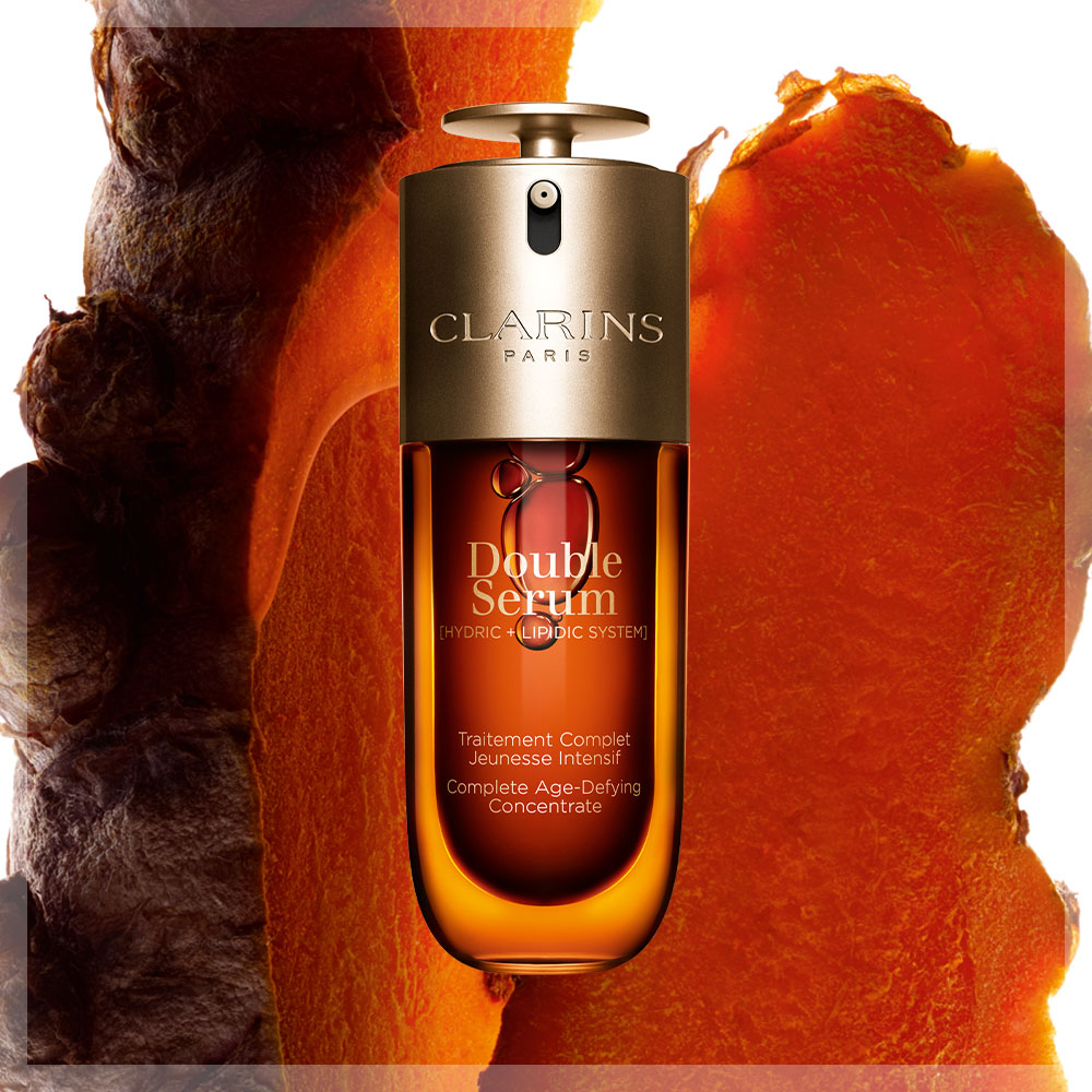 Clarins Double Serum-flaske med en glødende, gyllen bakgrunn. Flasken har et elegant design med teksten «Double Serum» og «Hydric + Lipidic System».