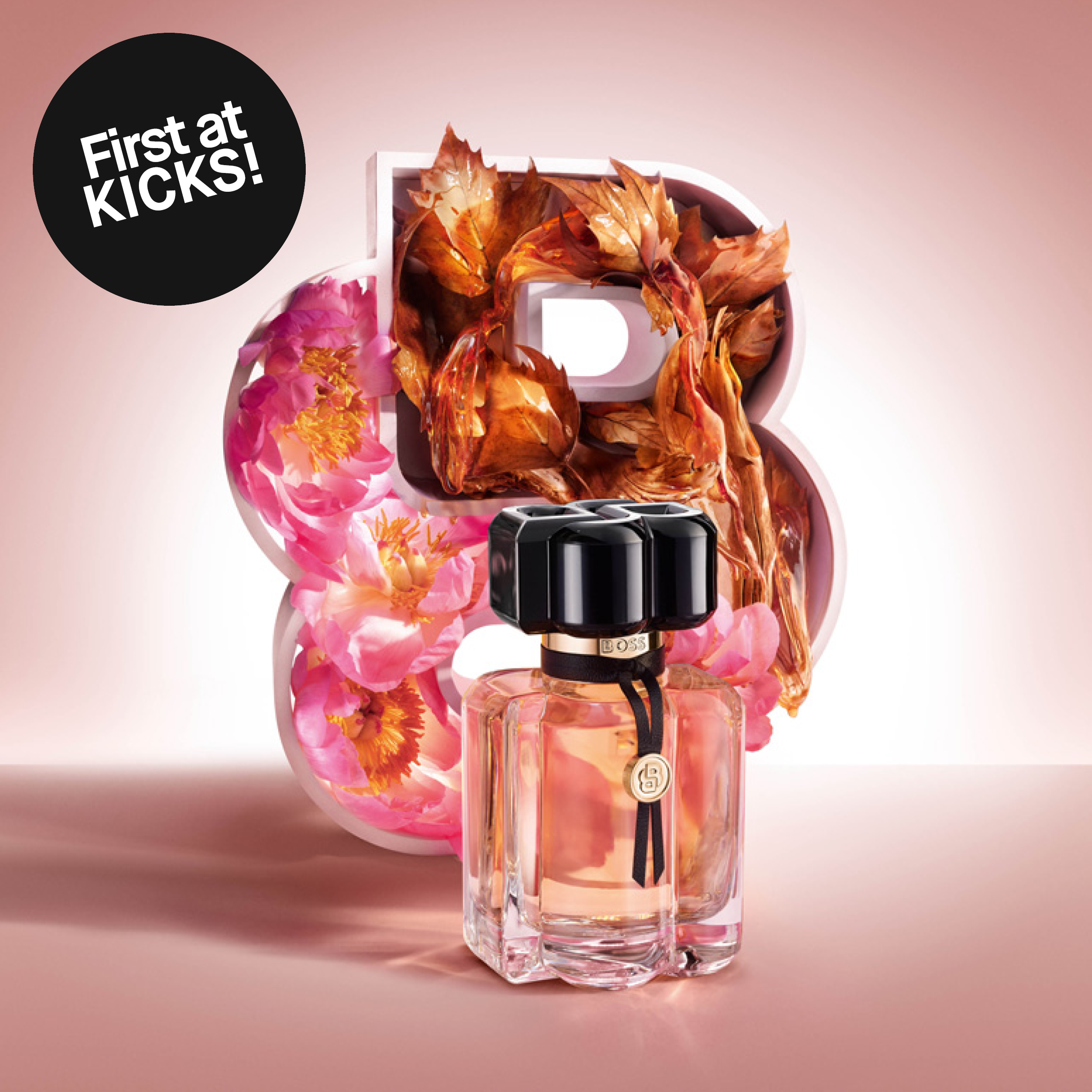 Boss The Scent-parfym mot rosa bakgrund framför blommor och höstlöv. Bilden innehåller texten ”First at KICKS!”.