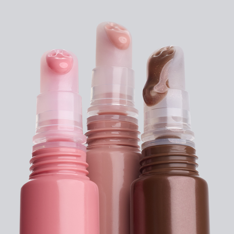 Tre IsaDora läpprodukter i rosa, nude och brun nyans med krämig och glansig textur synlig på toppen mot ljus bakgrund. Läppstift i stickformat med synlig produktkonsistens.