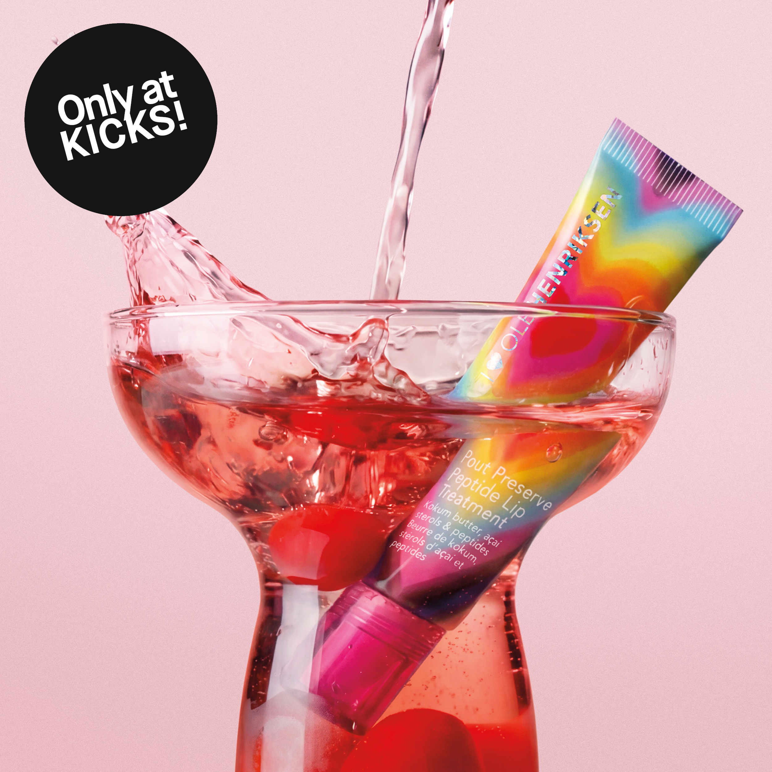 Ole Henriksen -huulihoitotuote cocktail-lasissa roiskeveden keskellä vaaleanpunaisella taustalla. Kuvassa teksti: ”Only at KICKS!”.