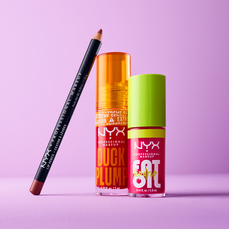 Tre NYX Professional Makeup-produkter mot en lilla bakgrunn. Produktene består av en svart leppeblyant, en oransje flaske og en rød flaske med grønt lokk.