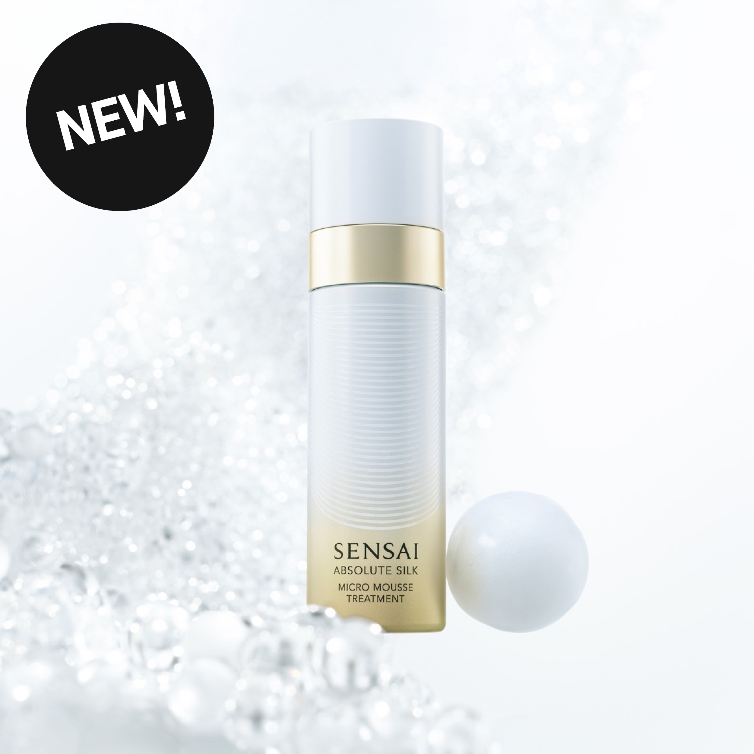 Sensai Absolute Silk Micro Mousse Treatment hudvård i vit och guldfärgad flaska mot en ljus bakgrund med bubblor och en vit sfär. Texten ”SENSAI”, ”ABSOLUTE SILK”, ”MICRO MOUSSE TREATMENT” och ”NEW!” syns i bilden.