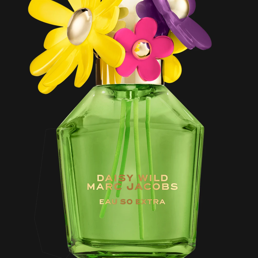 Marc Jacobs Daisy Wild Eau So Extra vihreässä lasipullossa, jonka korkissa on koristeellisia kukkia, mustaa taustaa vasten. Pullossa näkyy teksti "DAISY WILD MARC JACOBS EAU SO EXTRA".