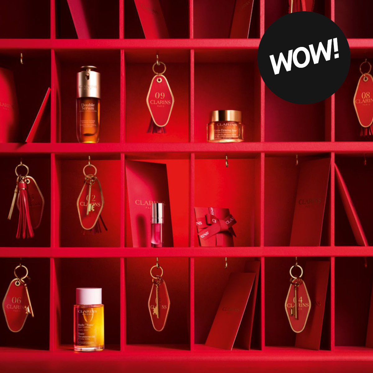 Clarins hudvård presenterad i ett rött hyllsystem med produkter som Double Serum, Extra-Firming Day Cream och Lip Comfort Oil. Röda Clarins-nyckelbrickor med siffrorna 02, 04, 06, 08 och 09 samt en svart cirkel med texten "WOW!" syns i bilden.