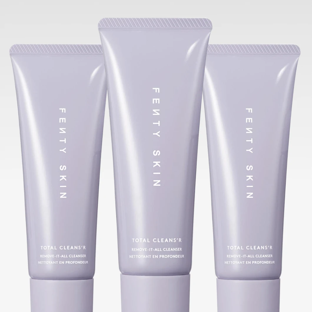 Tre tuber av Fenty Skin Total Cleans’r Remove-It-All Cleanser står uppradade mot ljus bakgrund, med ljuslila förpackningar och vit text.