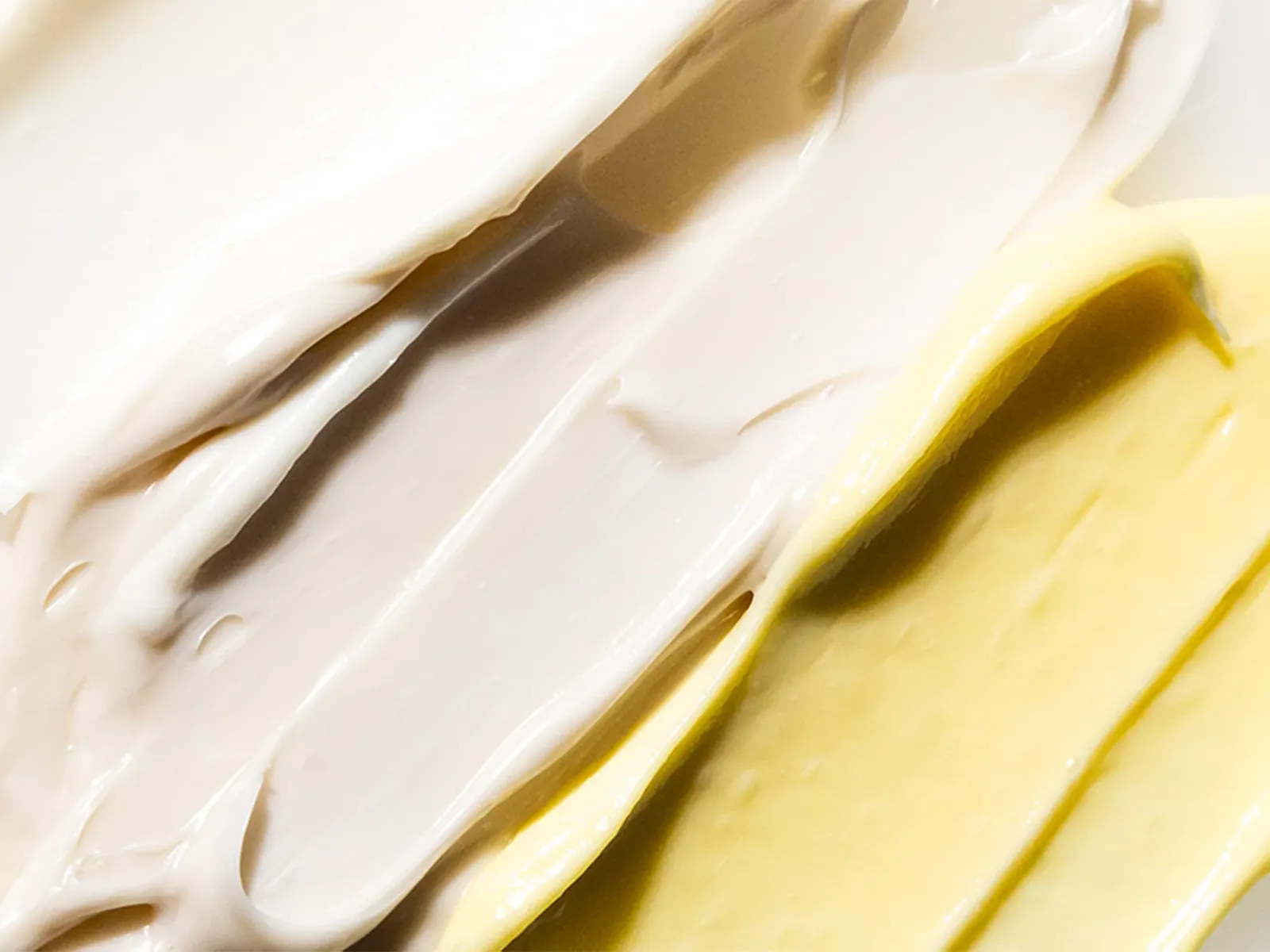 Närbild på textur av vit och gul peelingcreme.