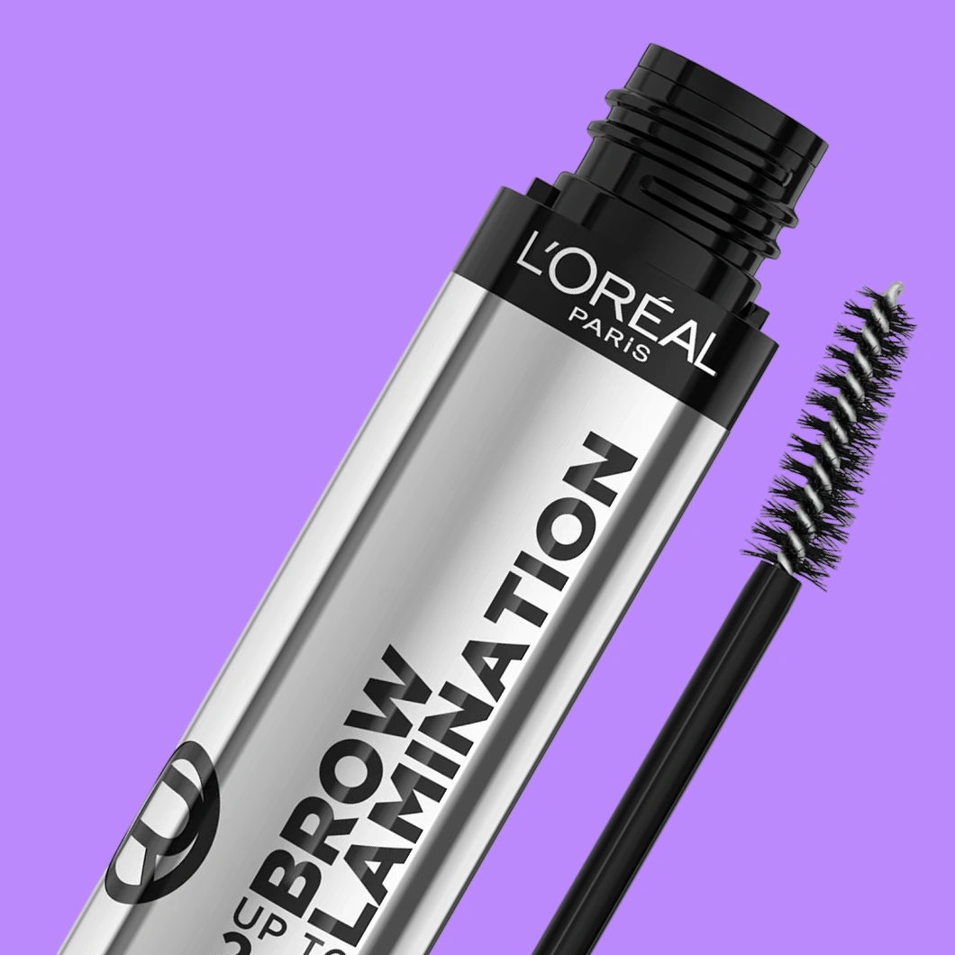 L’Oréal Paris Brow Lamination ögonbrynsprodukt i silverfärgad förpackning med svart spiralborste mot lila bakgrund. Texten ”L’ORÉAL PARIS” och ”BROW LAMINATION” syns på förpackningen.