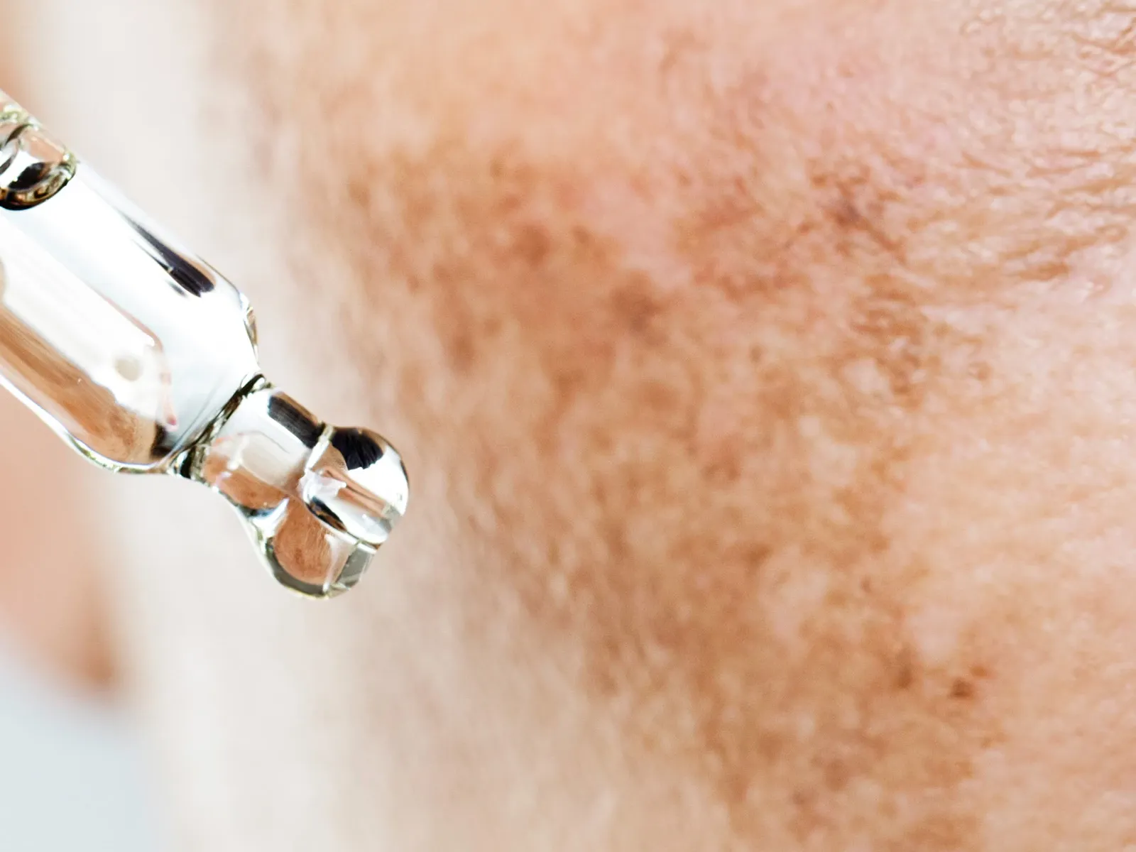 Nærbilde av en pipette som påfører serum på huden.