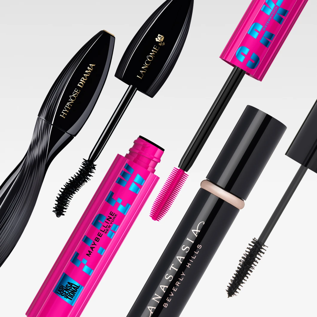 Produktbild med flera mascaror i olika färger och former. Öppna och stängda mascaraförpackningar med synliga borstar visas diagonalt mot ljus bakgrund. Märken som syns är Lancôme Hypnôse Drama, Lancôme mascara, Maybelline Lash Sensational Sky High och Anastasia Beverly Hills mascara.
