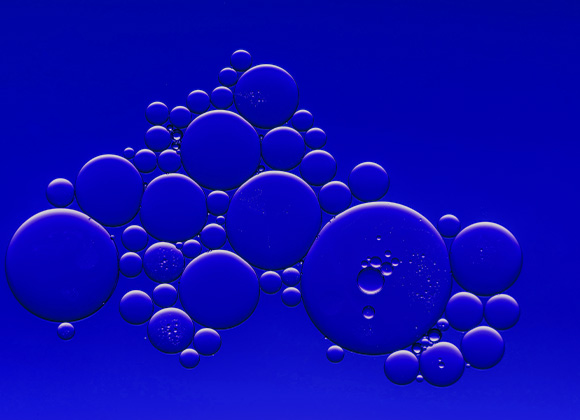 Sinisiä kuplia eri kokoisina sinistä taustaa vasten.