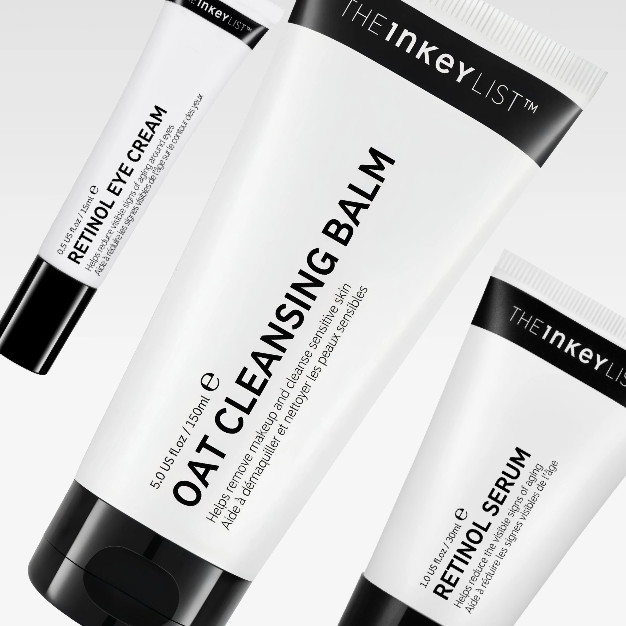 The INKEY List hudpleieprodukter med Oat Cleansing Balm, Retinol Eye Cream og Retinol Serum i hvite tuber med svart tekst mot lys grå bakgrunn. Synlig tekst inkluderer “helps remove makeup and cleanse sensitive skin” og “helps reduce the visible signs of aging”.
