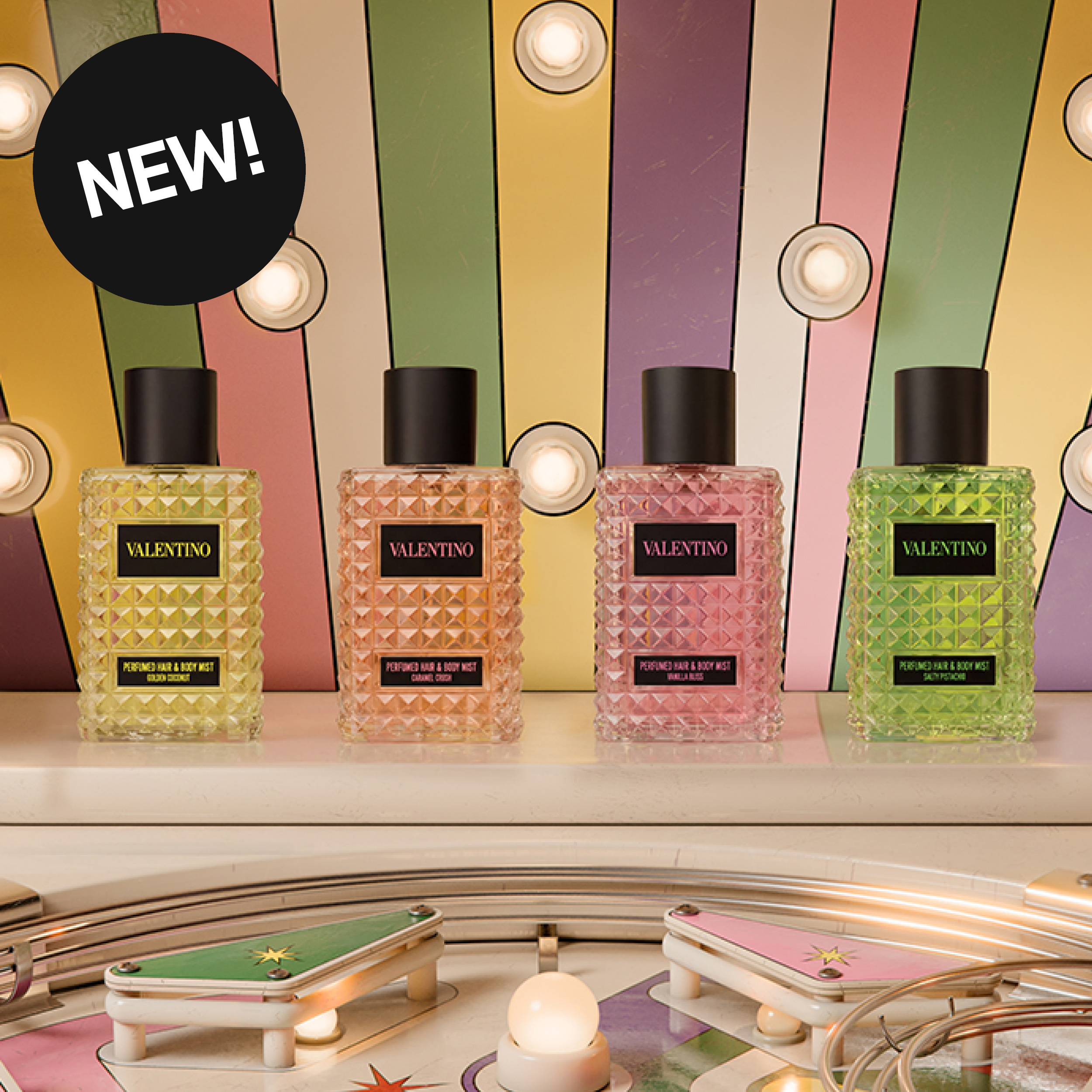 Fyra Valentino Perfumed Hair & Body Mist-flaskor står på en hylla framför en färgglad bakgrund med lampor och texten ”NEW!”. På flaskorna syns texterna ”VALENTINO”, ”PERFUMED HAIR & BODY MIST”, ”GOLDEN GODDESS”, ”CHARME COUTURE”, ”VANILLA BLOSS” och ”SUMMER PASSION”.