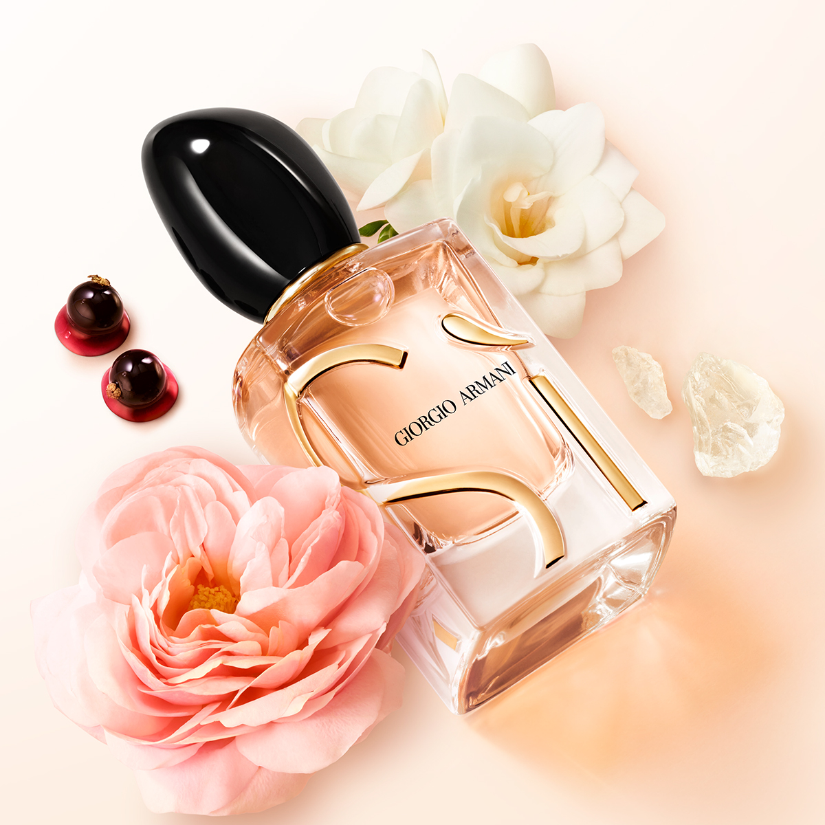 Giorgio Armani Sì parfymflaska mot ljus bakgrund med blommor, bär och kristalliknande detaljer.