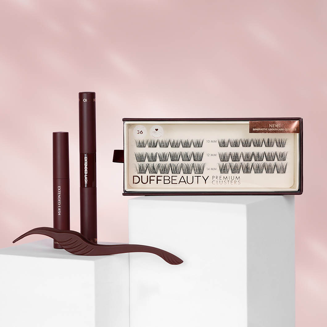 Kaksi Duff Beauty -silmätuotetta valkoisilla jalustoilla vaaleanpunaista taustaa vasten. Musta tarra tekstillä "NEW".