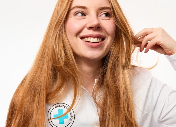 Kicks beautyexpert Rebecka i vit rock med Beauty Pharmacy logga på bröstet.